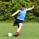 boy kicking ball on a pitch