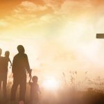 family in front of a cross