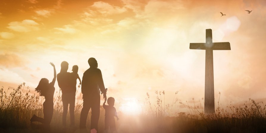 family in front of a cross