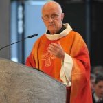 priest talking to students