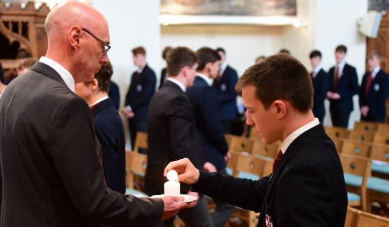 Student picking up a candle to light it