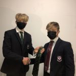 students, wearing masks, exchanging ties