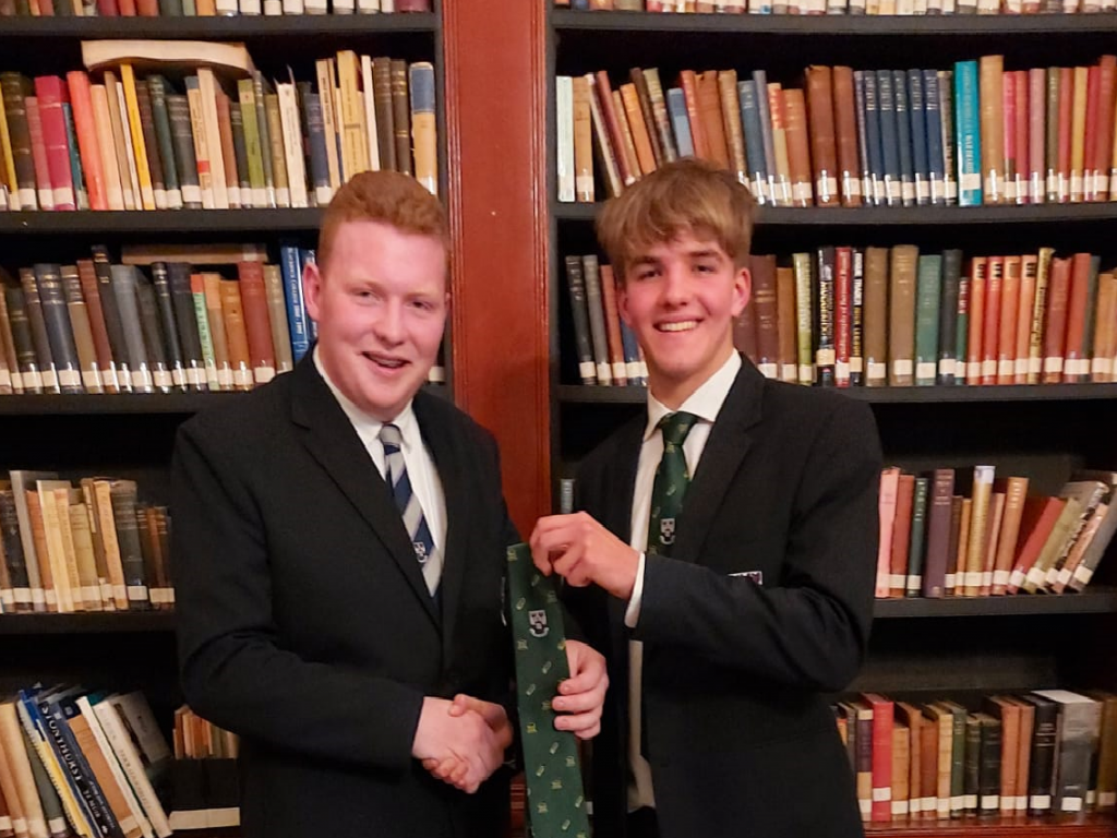 2 boys holding a new tie