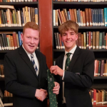 2 boys holding a new tie