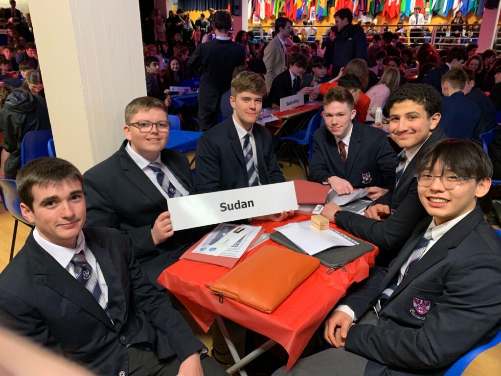 a group of smartly dressed teenage boys sitting around a table